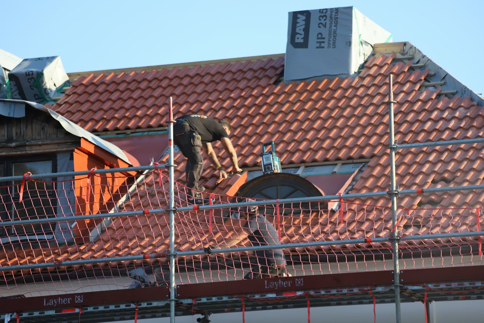 Toiture en tuiles rouges en cours de rénovation avec échafaudage