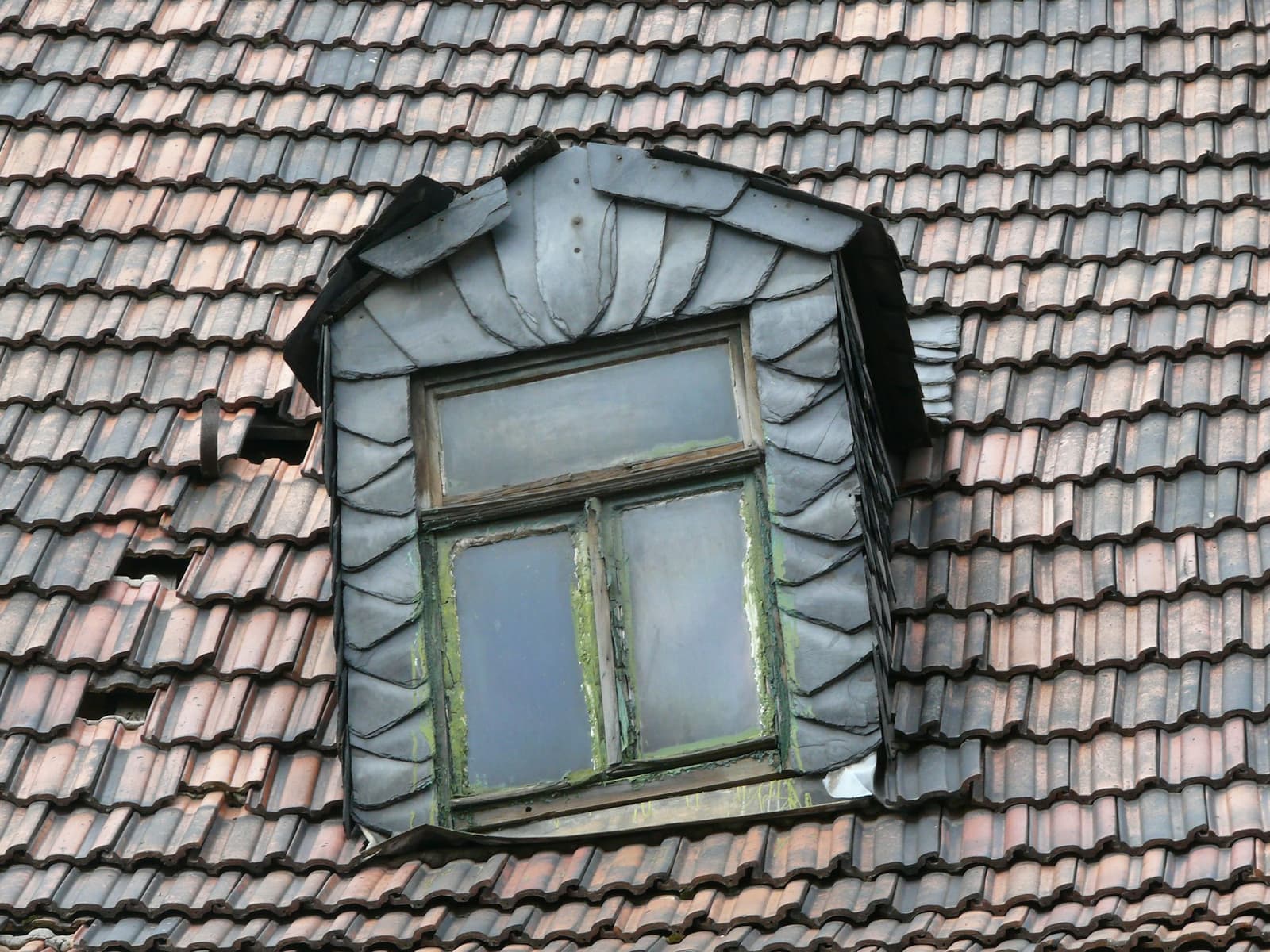 Lucarne en zinc sur une toiture en tuiles anciennes